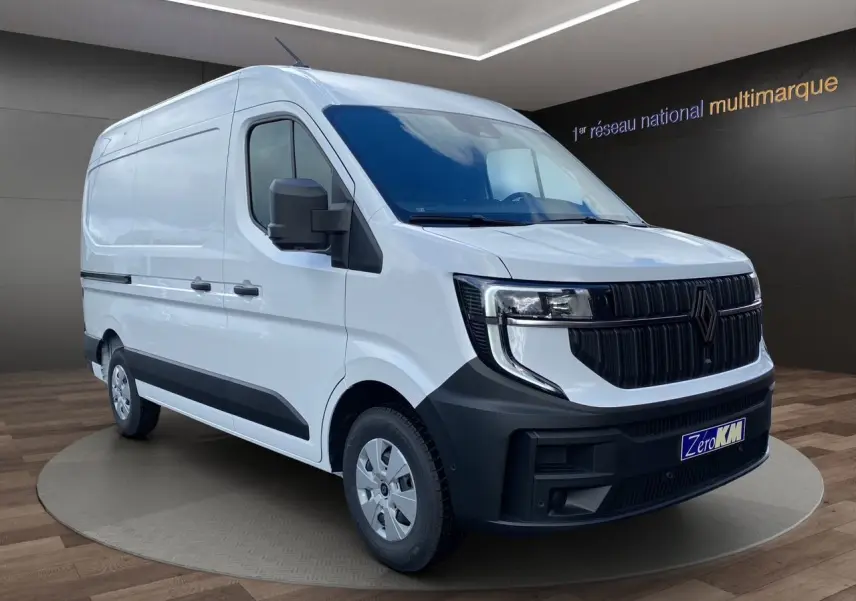 Vue 3/4 avant droit d’un Renault Master blanc 2025 avec calandre noire et pare-chocs noir mat, présenté en showroom.