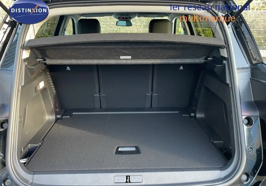 Coffre ouvert vu de l'arrière d'un Citroën C5 Aircross noir Perla Metal, avec cache-bagages en place.
