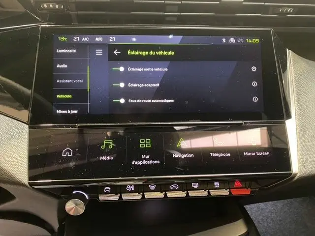 Vue rapprochée de l’écran tactile central et de la console de la Peugeot 308 hybride blanche, affichant les réglages d’éclairage du véhicule.