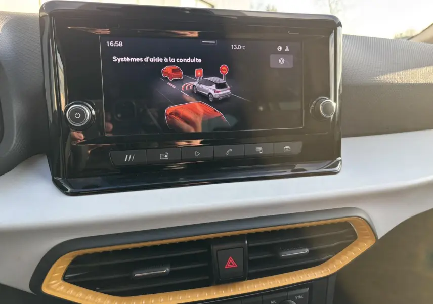 Vue rapprochée de l’écran tactile central du tableau de bord du SEAT Arona 2025 avec affichage des aides à la conduite.