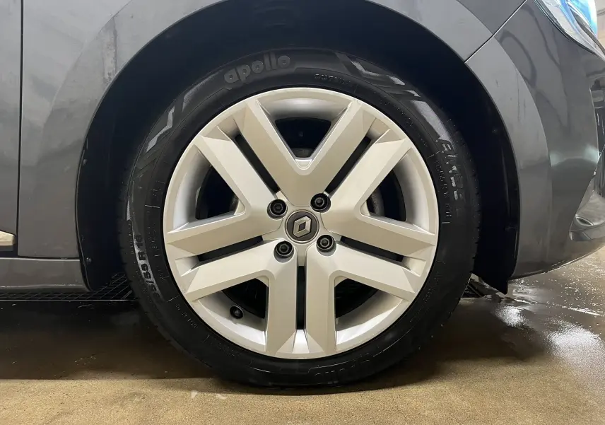 Gros plan sur la roue avant droite d'une Renault Clio V Business gris titanium avec jante alliage distinctive.