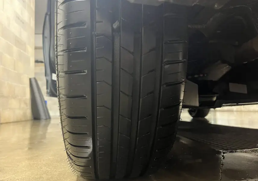 Gros plan sur le pneu avant droit d'une Renault Clio V gris titanium, montrant le profil et la bande de roulement.