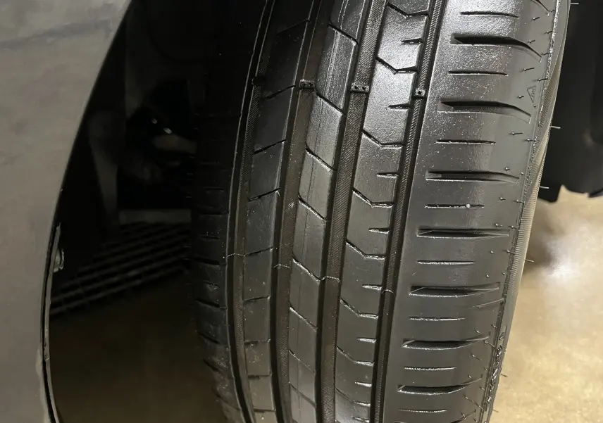 Gros plan sur le pneu avant droit d'une Renault Clio V Business gris Titanium de 2019, montrant la bande de roulement.