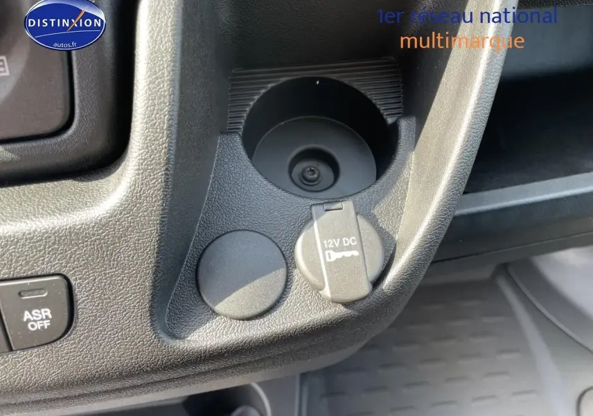 Détail intérieur montrant la prise 12V et le porte-gobelet du Peugeot Boxer Fourgon blanc, version 2023.