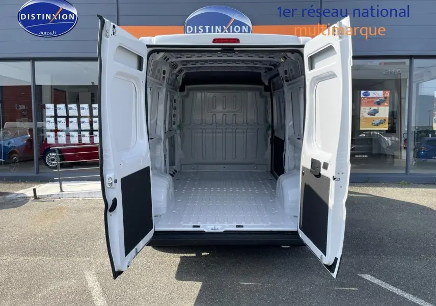 Vue arrière du Peugeot Boxer Fourgon blanc 2023 avec portes ouvertes montrant la grande zone de chargement vide.