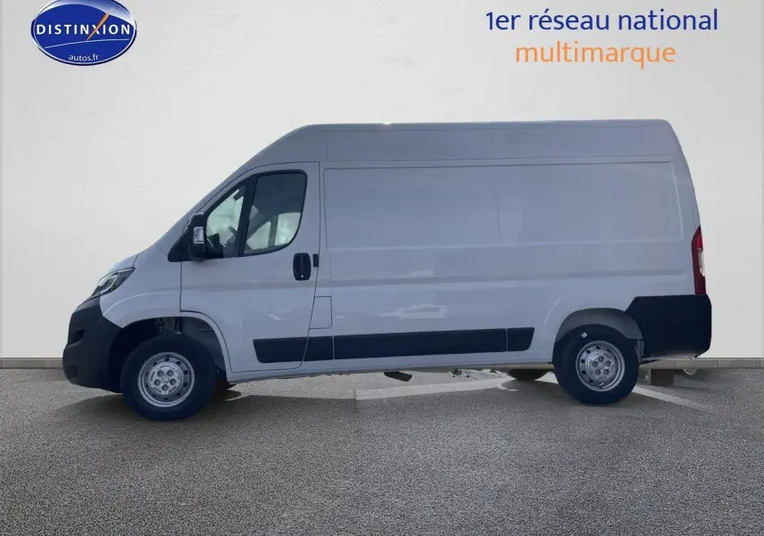 Vue de profil côté gauche d’un Peugeot Boxer Fourgon blanc 2023 avec protections noires sur les bas de caisse.