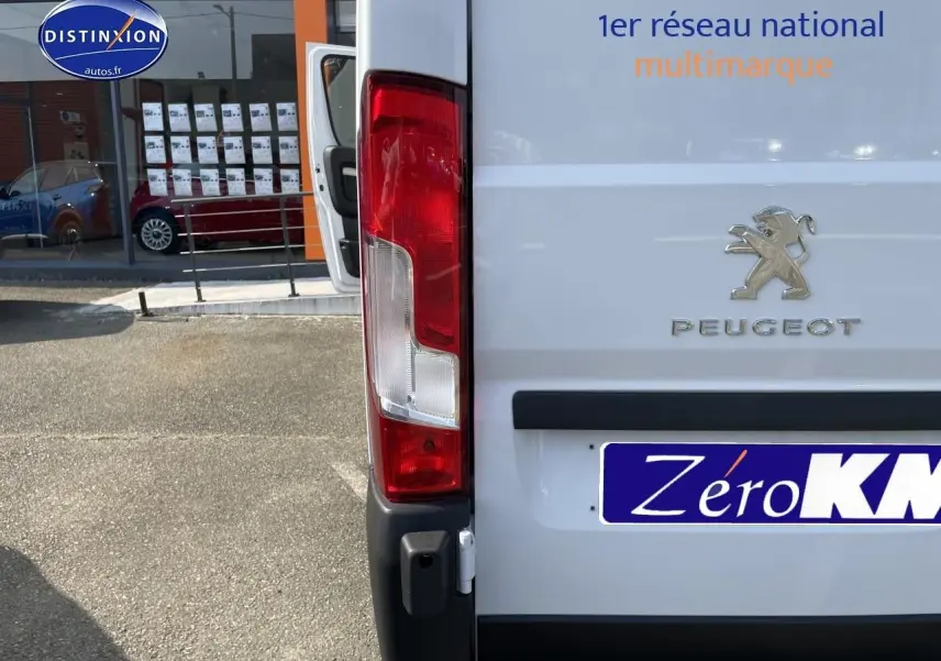 Vue arrière droite du Peugeot Boxer Fourgon blanc 2023 avec feux arrière et logo visibles.