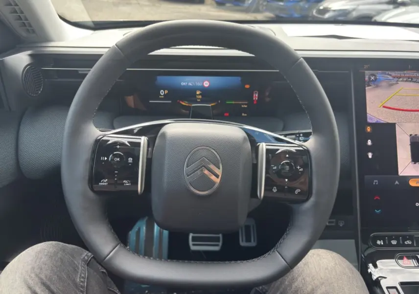 Vue intérieure centrée sur le volant cuir multifonctions de la Citroën C5 Aircross New Hybrid 2026 avec écran numérique.