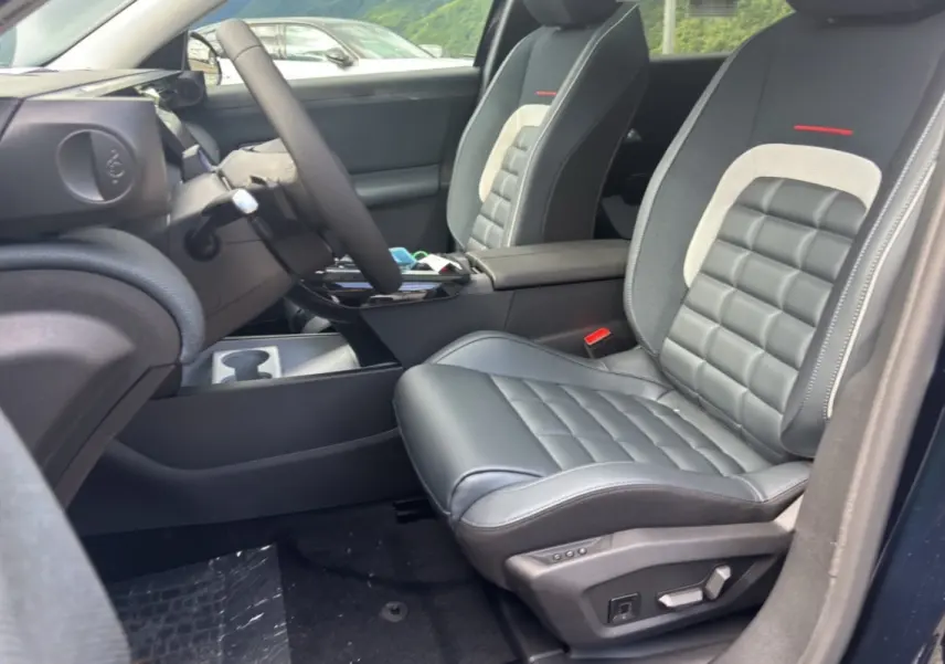 Vue intérieure côté conducteur du Citroën C5 Aircross New Hybrid 2026, sièges cuir noir avec surpiqûres grises et accoudoir central.