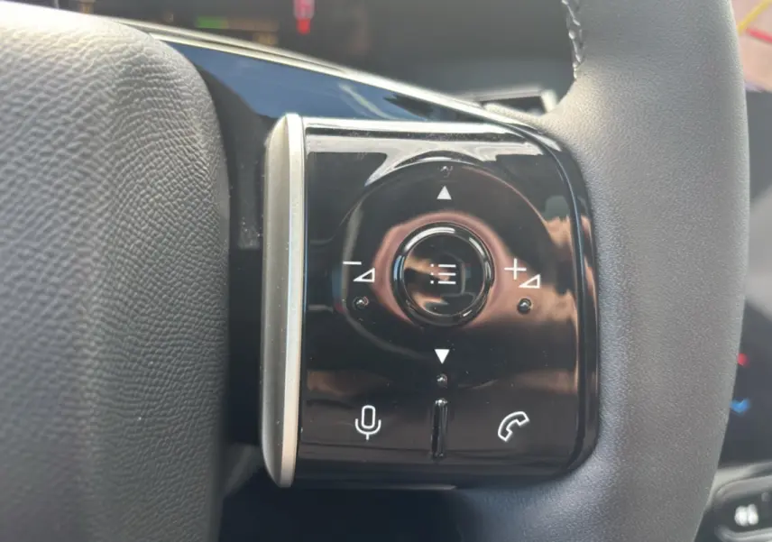 Gros plan sur les commandes multifonctions noires du volant cuir du Citroën C5 Aircross New Hybrid 2026.