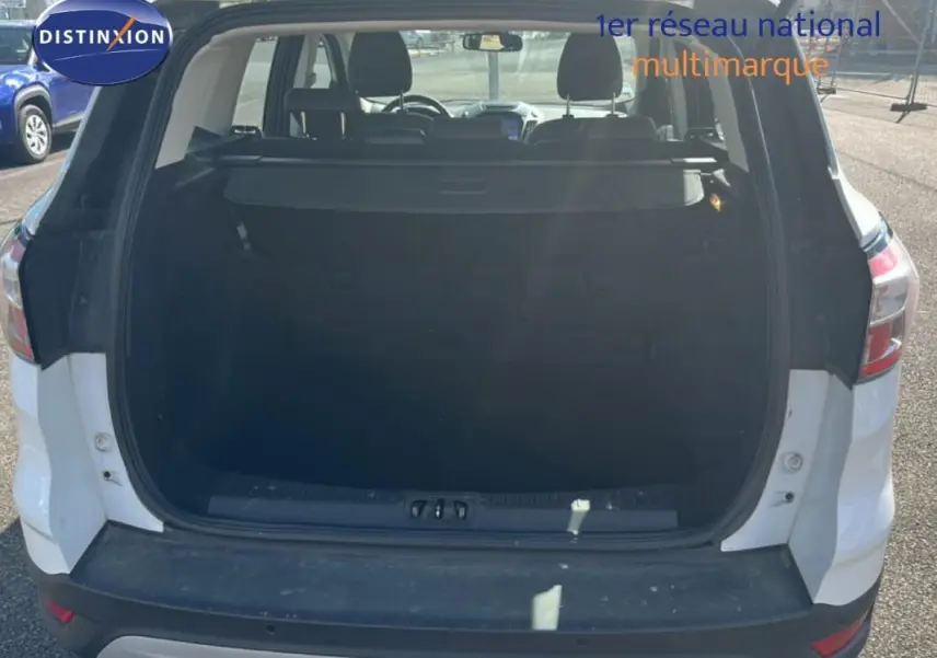 Vue arrière du coffre ouvert d'un Ford Kuga blanc 2019, montrant l'espace de chargement intérieur.
