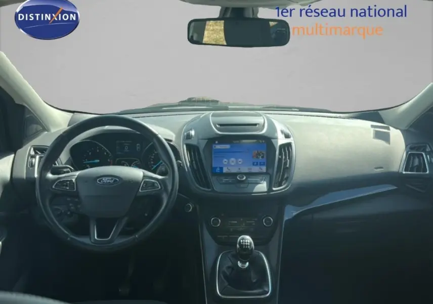Vue intérieure avant du Ford Kuga 2019, tableau de bord noir avec volant cuir et écran tactile central.