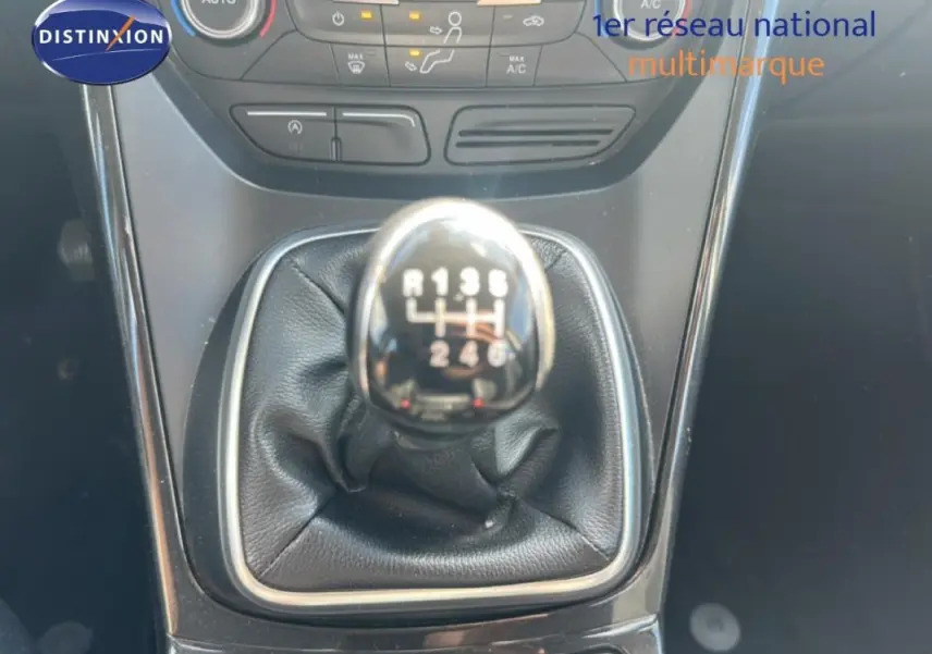 Gros plan sur le levier de vitesses manuel noir du Ford Kuga blanc 2019, avec console centrale et commandes climatisation visibles.