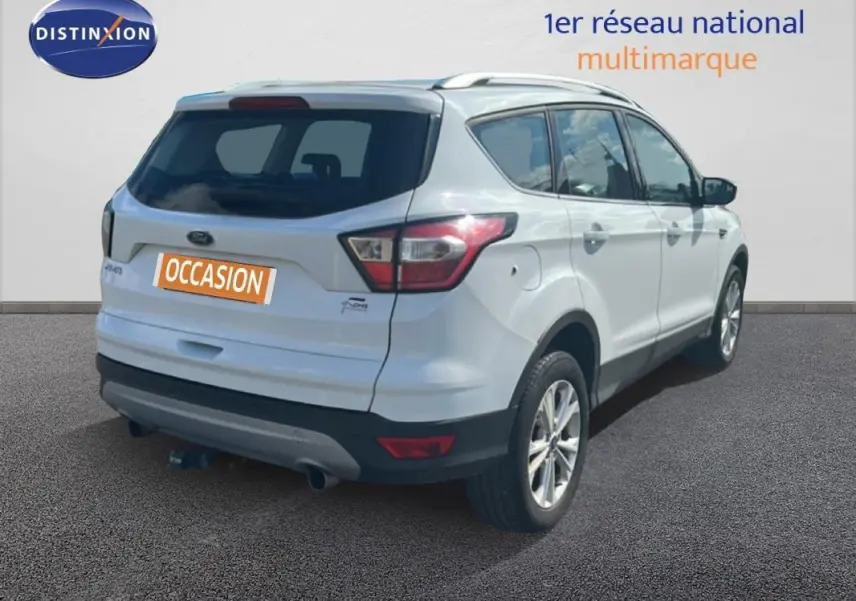 Vue 3/4 arrière droite d'un Ford Kuga blanc 2019 avec barres de toit et jantes alliage 17 pouces.