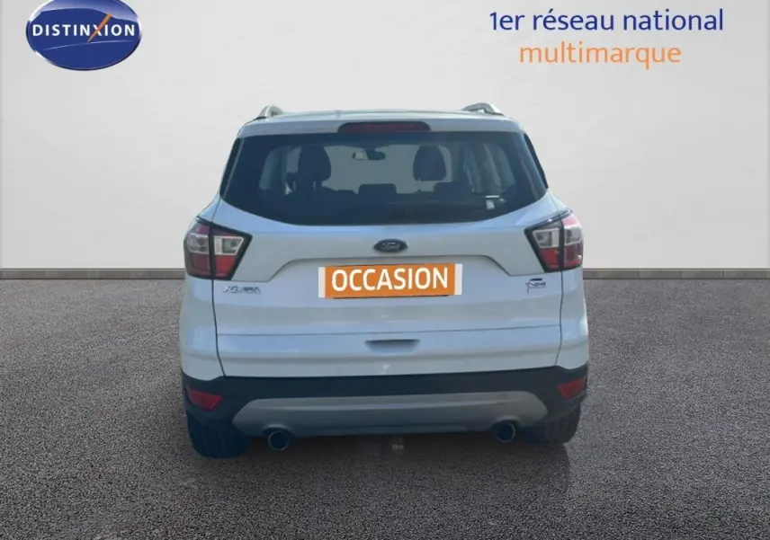 Vue arrière d’un Ford Kuga blanc 2019 avec barres de toit et double sortie d’échappement visible.