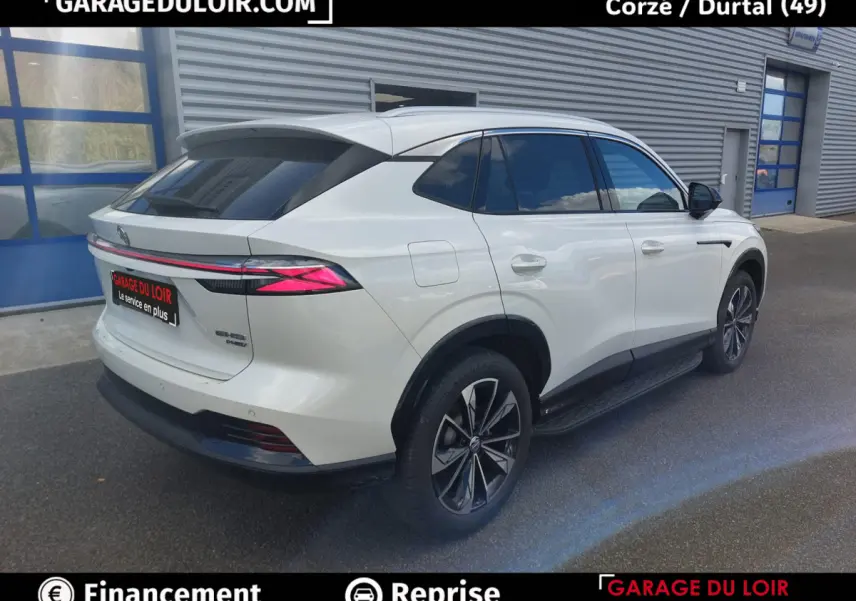 Vue 3/4 arrière droite d'un MG Motor EHS hybride rechargeable blanc avec feux arrière LED distinctifs et jantes noires.