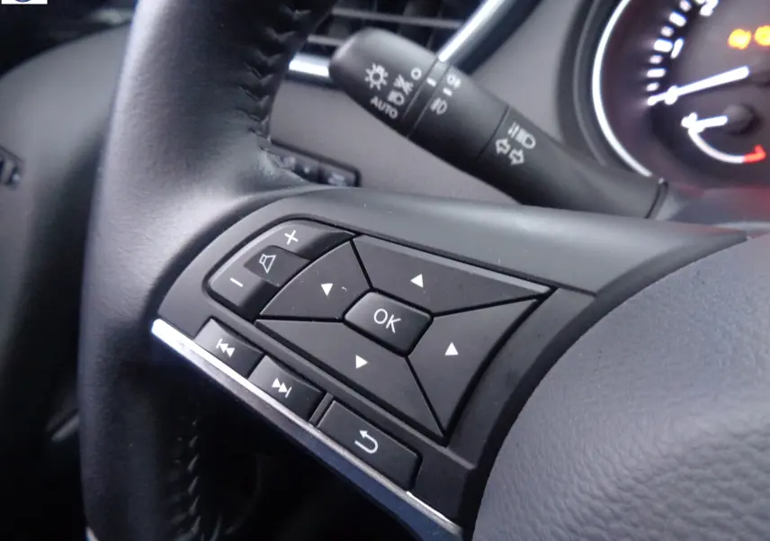 Gros plan sur les commandes multifonctions du volant noir du Nissan Qashqai blanc lunaire 2020.