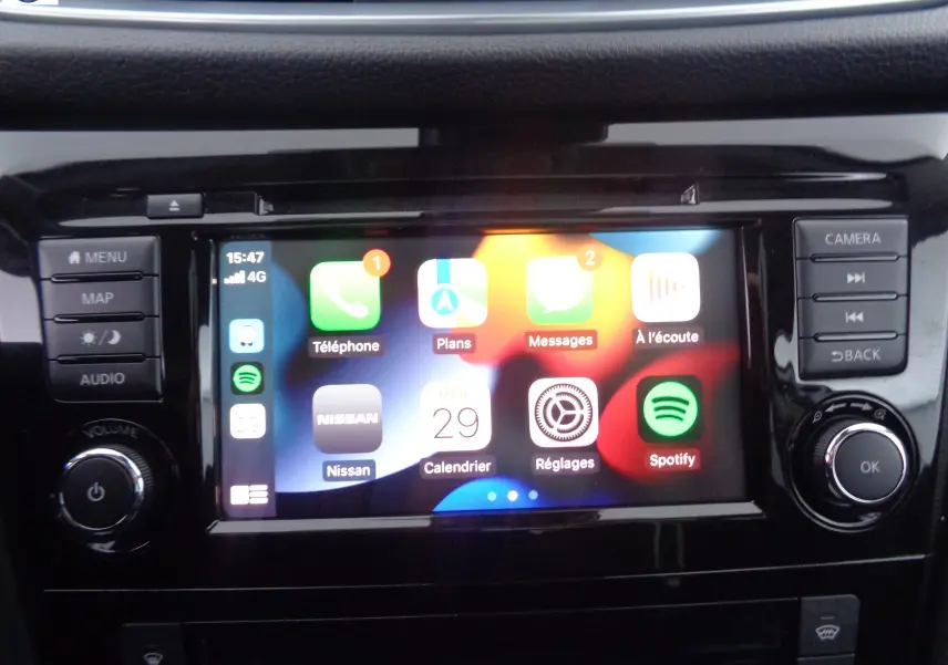 Écran tactile central du Nissan Qashqai 2020 affichant les applications Apple CarPlay avec commandes autour en finition noire brillante.