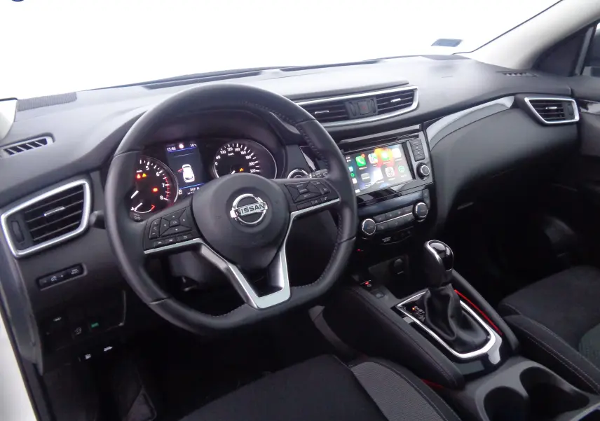 Vue intérieure du tableau de bord et volant noir du Nissan Qashqai 2020 avec écran tactile et levier de boîte automatique.