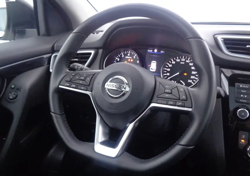 Vue rapprochée du volant noir du Nissan Qashqai 2020 avec commandes intégrées et tableau de bord éclairé.