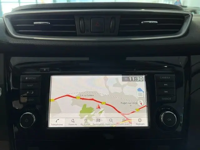 Vue rapprochée de l'écran tactile central du Nissan Qashqai 2020 blanc lunaire, affichant la navigation GPS en cours.