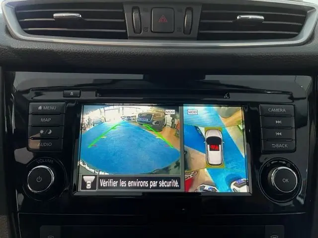 Écran central du Nissan Qashqai blanc lunaire montrant la caméra de recul et la vue à 360 degrés du véhicule.