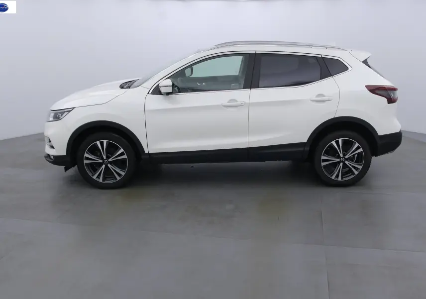 Profil côté gauche d'un Nissan Qashqai blanc lunaire métal de 2020 avec jantes alliage et vitres teintées.