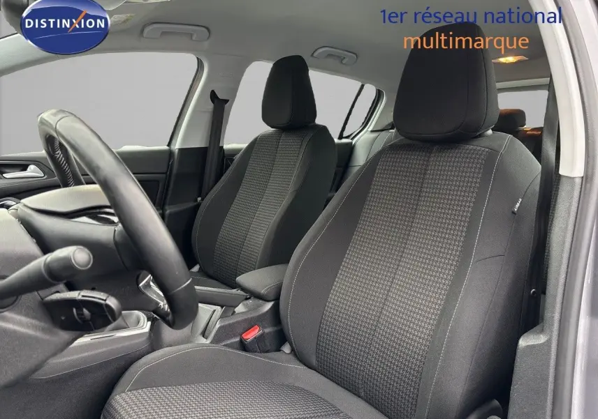 Intérieur de la Peugeot 308 2019, vue côté conducteur, sièges tissu noir avec motifs gris et volant visible.