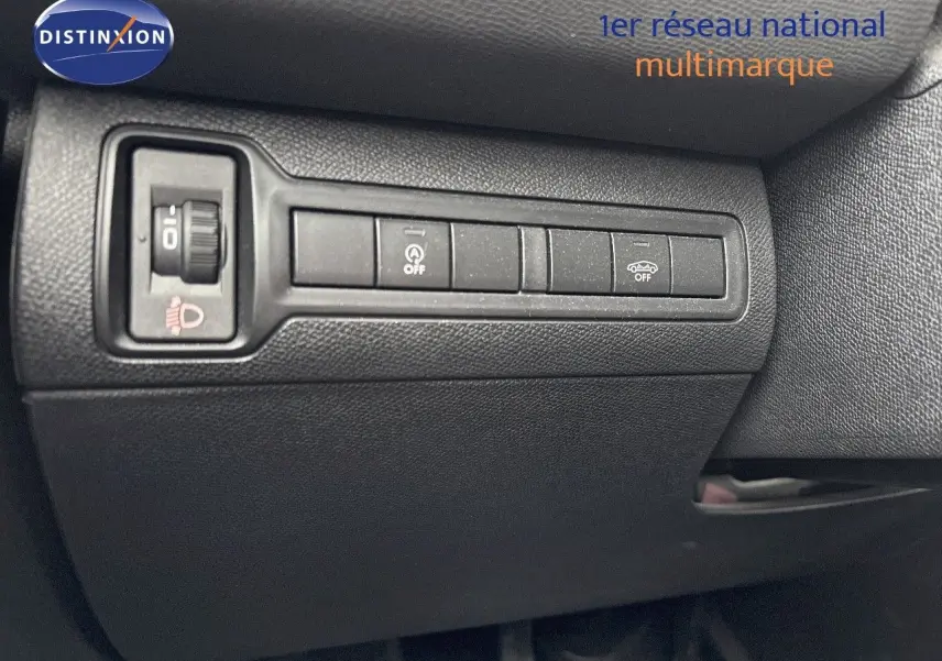 Gros plan sur les commandes de réglage des phares et assistances de conduite dans une Peugeot 308 gris Artense 2019, côté conducteur.