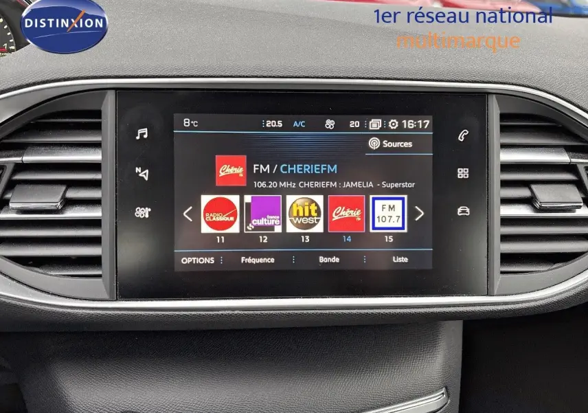 Écran tactile central du tableau de bord de la Peugeot 308 gris Artense, affichant les stations radio FM.