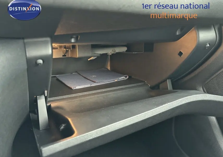 Gant de rangement ouvert côté passager dans une Peugeot 308 gris Artense 2019, montrant un livret à l'intérieur.