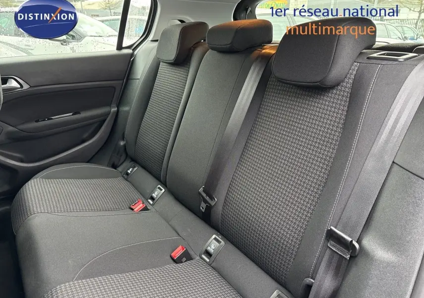Vue intérieure sur la banquette arrière en tissu noir de la Peugeot 308 gris Artense, avec ceintures et appuie-têtes visibles.