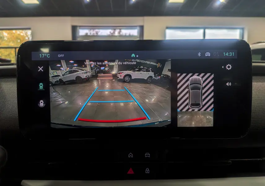 Écran multimédia de la FIAT 600 Hybrid bleu Sea montrant la caméra de recul avec guidage dynamique en intérieur showroom.