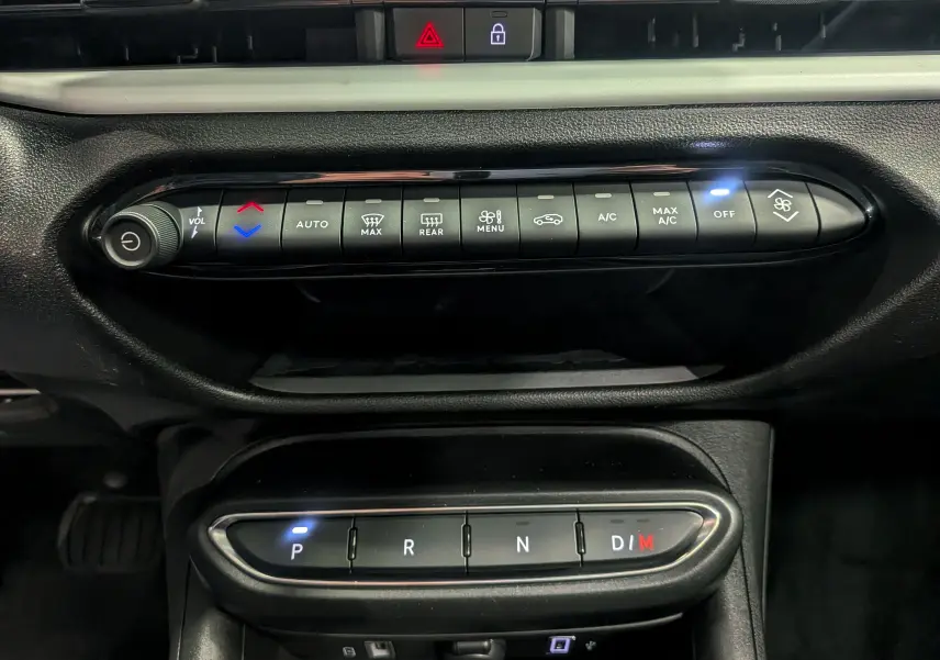 Gros plan sur la console centrale de la Fiat 600 Hybrid 2025 avec commandes climatisation et boîte auto en mode parking.