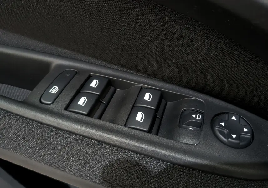 Gros plan sur les commandes électriques des vitres et rétroviseurs côté conducteur du FIAT 600 bleu Sea 2025.