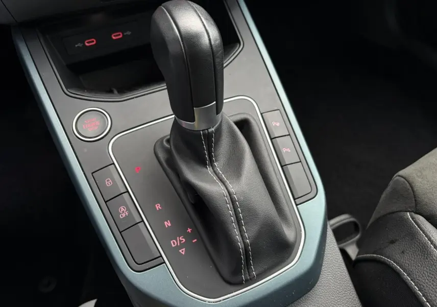 Gros plan sur la console centrale de la SEAT Arona 2025, avec levier de vitesse automatique en cuir noir et cadre gris magnétique.