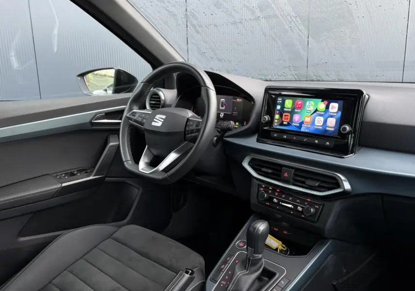 Vue intérieure côté conducteur du SEAT Arona 2025 avec tableau de bord digital et écran tactile central.