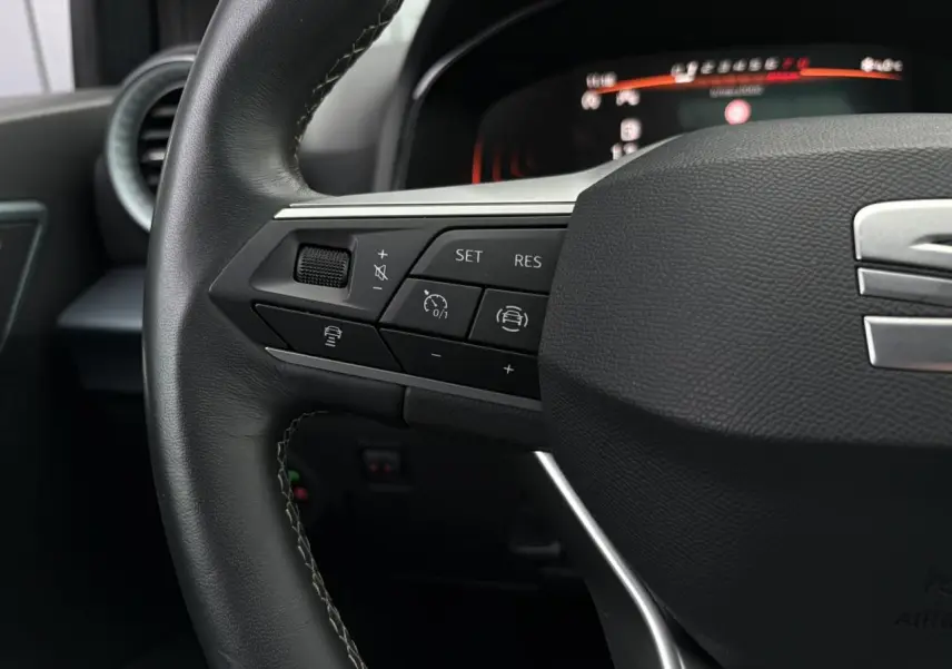 Gros plan sur le volant côté gauche du SEAT Arona 2025 avec commandes de régulateur de vitesse et assistance au maintien de voie.