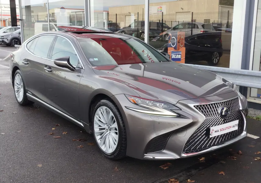 Lexus LS 500H gris manganèse vue 3/4 avant, mettant en valeur sa calandre distinctive et ses jantes élégantes.