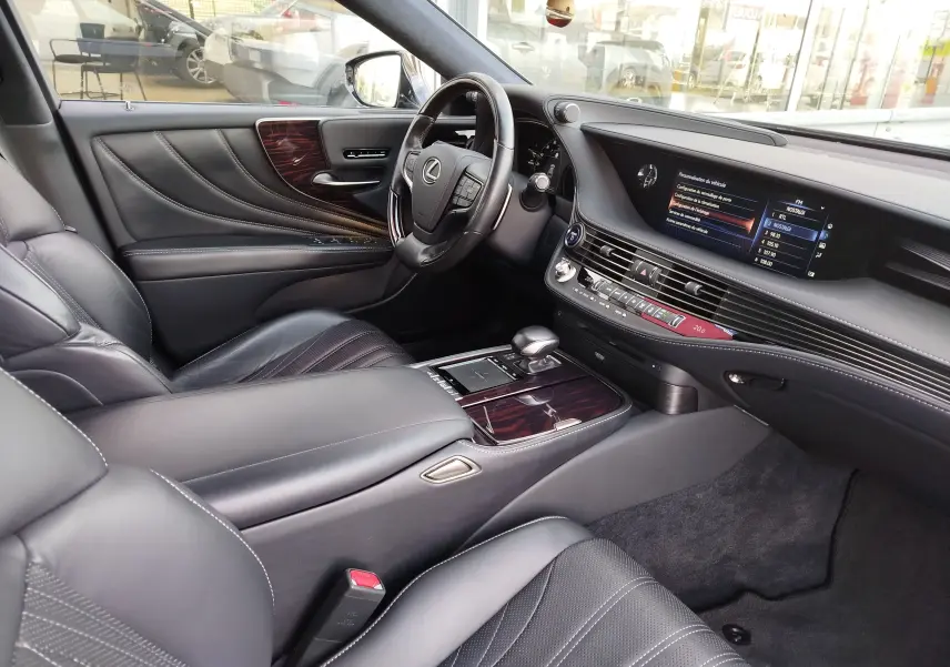 Intérieur noir cuir du Lexus LS 500H 2020 vu côté conducteur, avec tableau de bord et console centrale en bois verni.