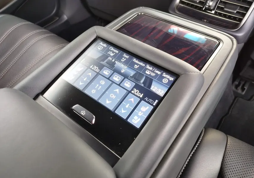 Vue rapprochée de l’écran tactile central du Lexus LS 500H 2020, avec commandes climatisation et sièges en cuir noir.