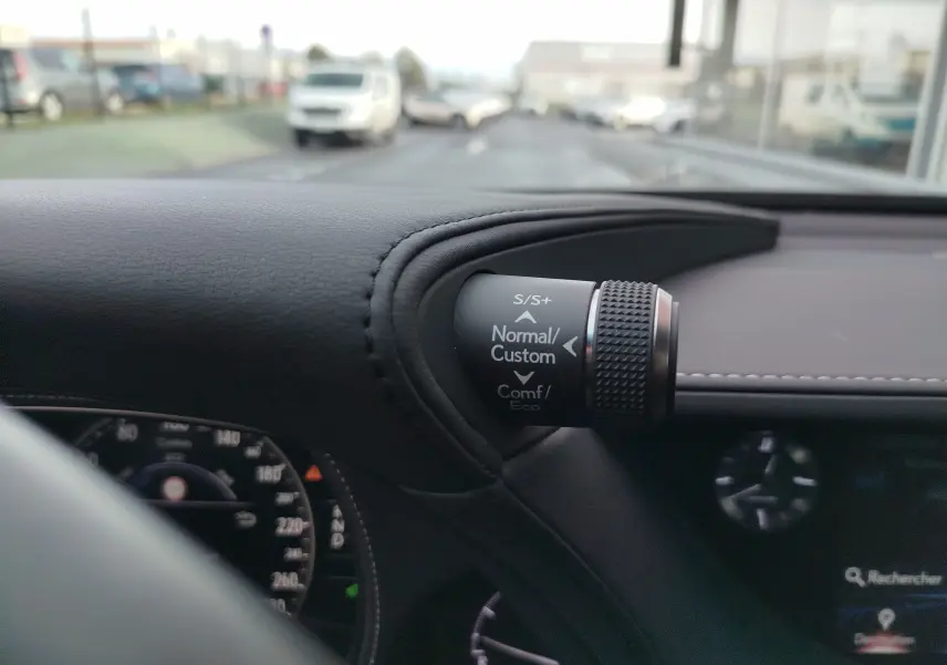 Détail du sélecteur de mode de conduite sur le tableau de bord en cuir noir d’une Lexus LS 500H gris manganèse, vue intérieure côté conducteur.