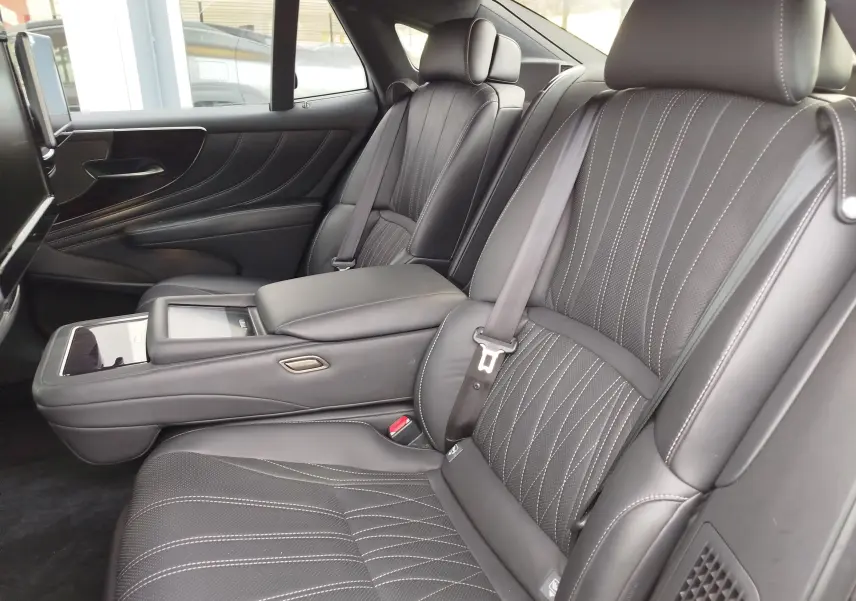 Vue intérieure latérale droite des sièges arrière en cuir noir avec surpiqûres blanches du Lexus LS 500H Executive.