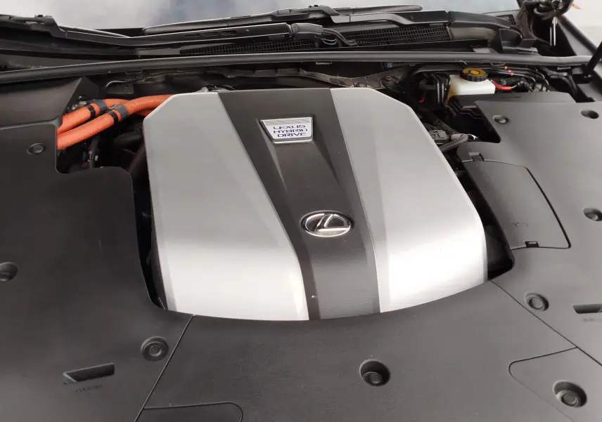 Vue rapprochée du moteur hybride Lexus LS 500H 2020 avec capot ouvert, mettant en valeur le cache moteur gris et noir.