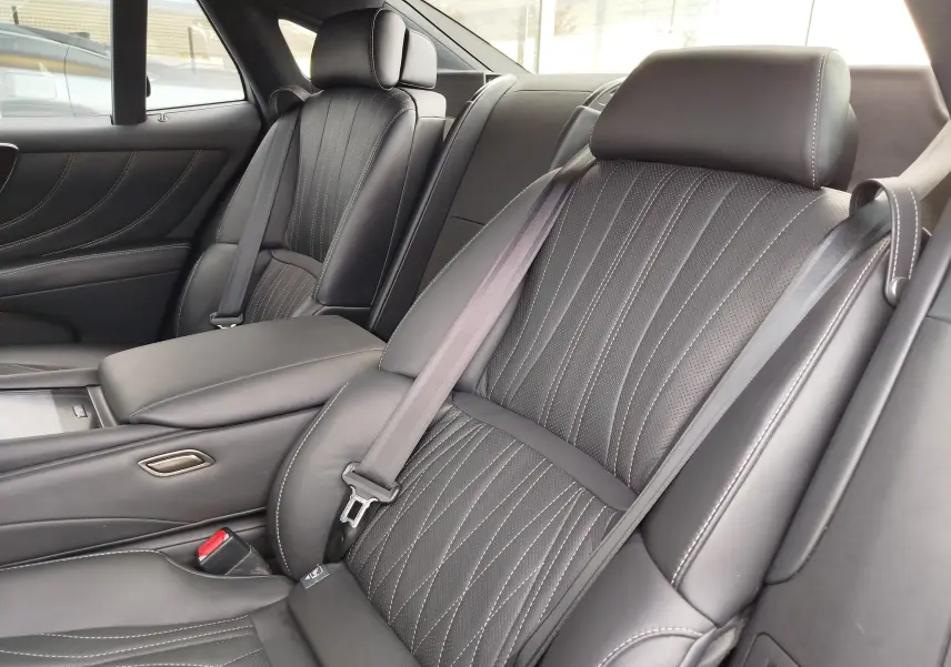 Vue intérieure rapprochée des sièges arrière en cuir noir avec surpiqûres blanches du Lexus LS 500H 2020.