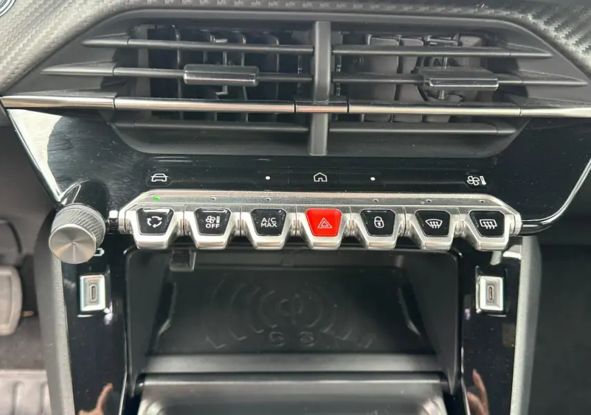 Vue rapprochée du tableau de bord central gris du Peugeot 2008 Hybrid 145 avec boutons de commande et prise USB.