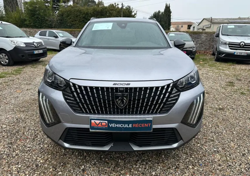 Vue de face du Peugeot 2008 Hybrid 145 gris, mettant en valeur sa calandre distinctive et ses feux LED verticaux.