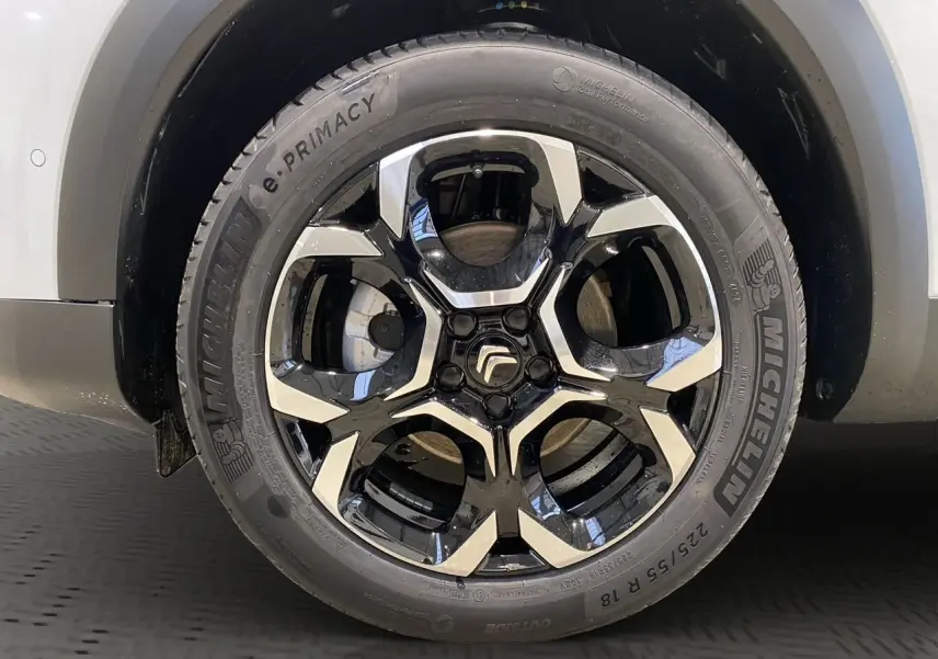 Gros plan sur la roue arrière droite d'un Citroën C5 Aircross blanc avec jante noire et pneus Michelin.