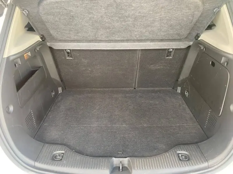 Coffre ouvert vu de l'arrière d'un Opel Mokka 2017, espace de chargement propre avec revêtement noir.