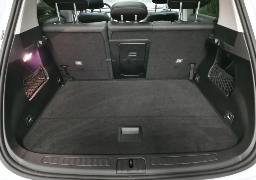 Coffre ouvert vu de l'arrière d'une Smart #1 blanche avec banquette arrière noire et filet de rangement latéral.